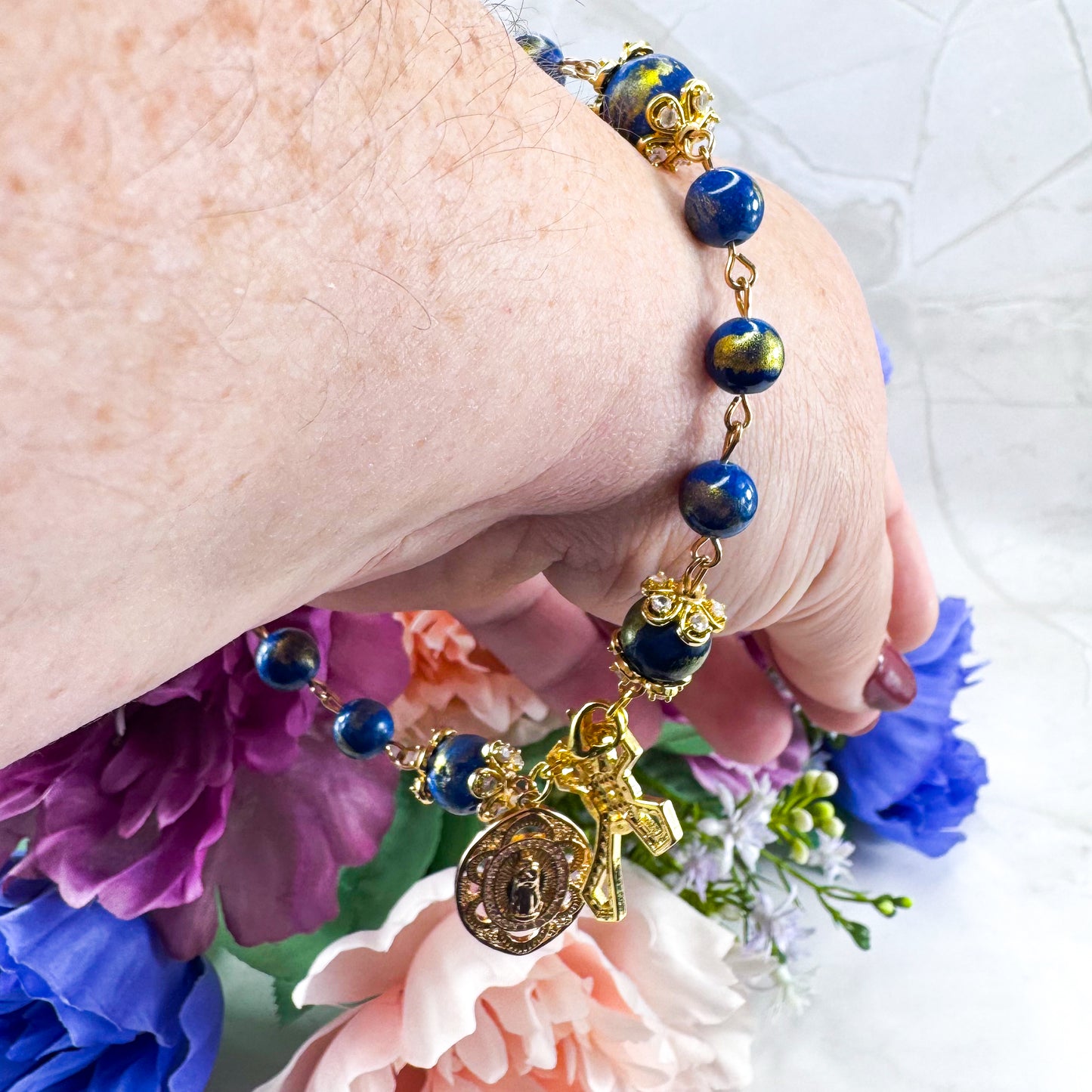 Luxury Catholic rosary bracelet handcrafted with natural Lapis Lazuli gemstone beads, a gold-tone cross with zirconia accents, and a Lady of Guadalupe medal. Adjustable beaded bracelet perfect for prayer, religious gifts, Confirmation, bridesmaid gifts, or everyday devotion. Made in Edmonton, AB, Canada.
