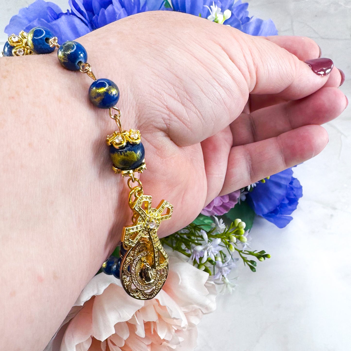 Luxury Catholic rosary bracelet handcrafted with natural Lapis Lazuli gemstone beads, a gold-tone cross with zirconia accents, and a Lady of Guadalupe medal. Adjustable beaded bracelet perfect for prayer, religious gifts, Confirmation, bridesmaid gifts, or everyday devotion. Made in Edmonton, AB, Canada.
