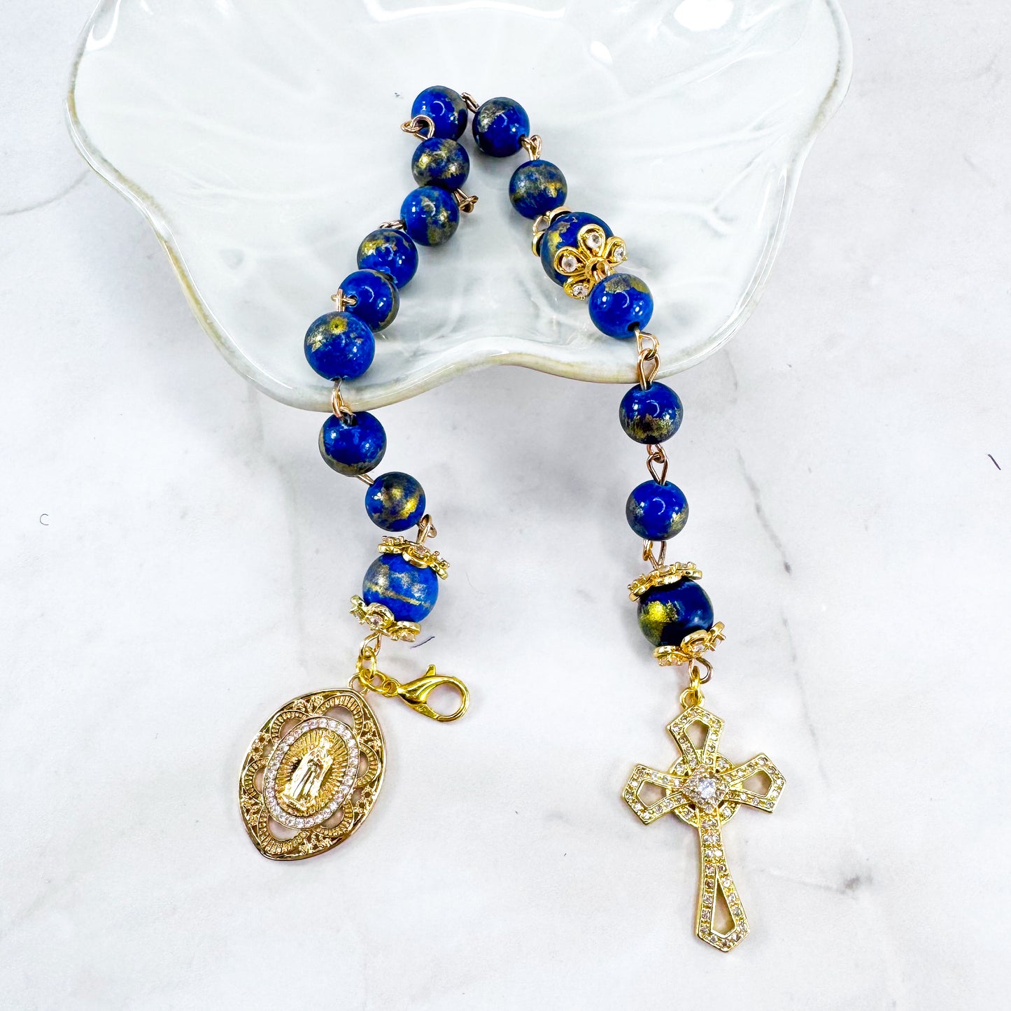Luxury Catholic rosary bracelet handcrafted with natural Lapis Lazuli gemstone beads, a gold-tone cross with zirconia accents, and a Lady of Guadalupe medal. Adjustable beaded bracelet perfect for prayer, religious gifts, Confirmation, bridesmaid gifts, or everyday devotion. Made in Edmonton, AB, Canada.