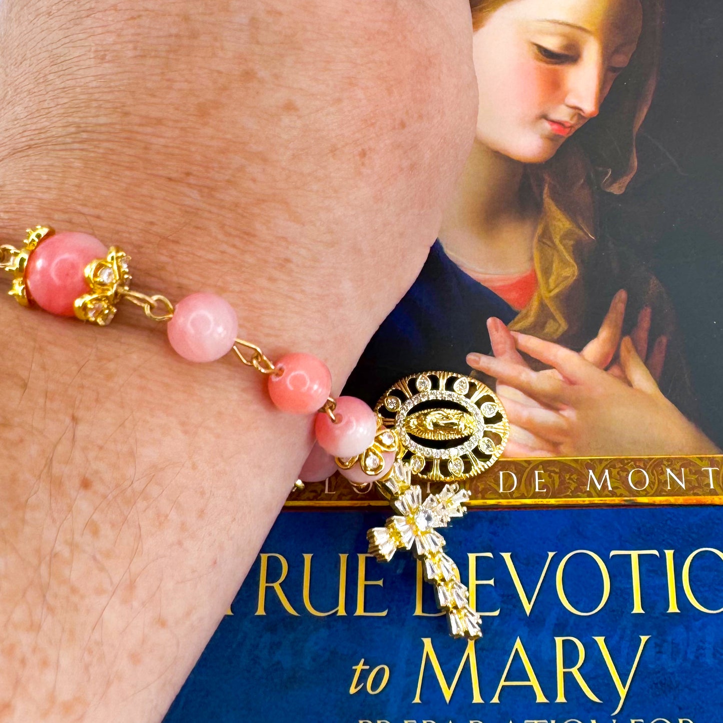 Luxury Catholic rosary bracelet handcrafted with natural pink persian jade gemstone beads, a gold-tone cross with zirconia accents, and a Lady of Guadalupe medal. Adjustable beaded bracelet perfect for prayer, religious gifts, Confirmation, bridesmaid gifts, or everyday devotion. Made in Edmonton, AB, Canada.
