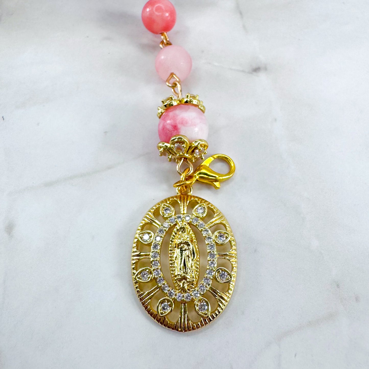 Luxury Catholic rosary bracelet handcrafted with natural pink persian jade gemstone beads, a gold-tone cross with zirconia accents, and a Lady of Guadalupe medal. Adjustable beaded bracelet perfect for prayer, religious gifts, Confirmation, bridesmaid gifts, or everyday devotion. Made in Edmonton, AB, Canada.