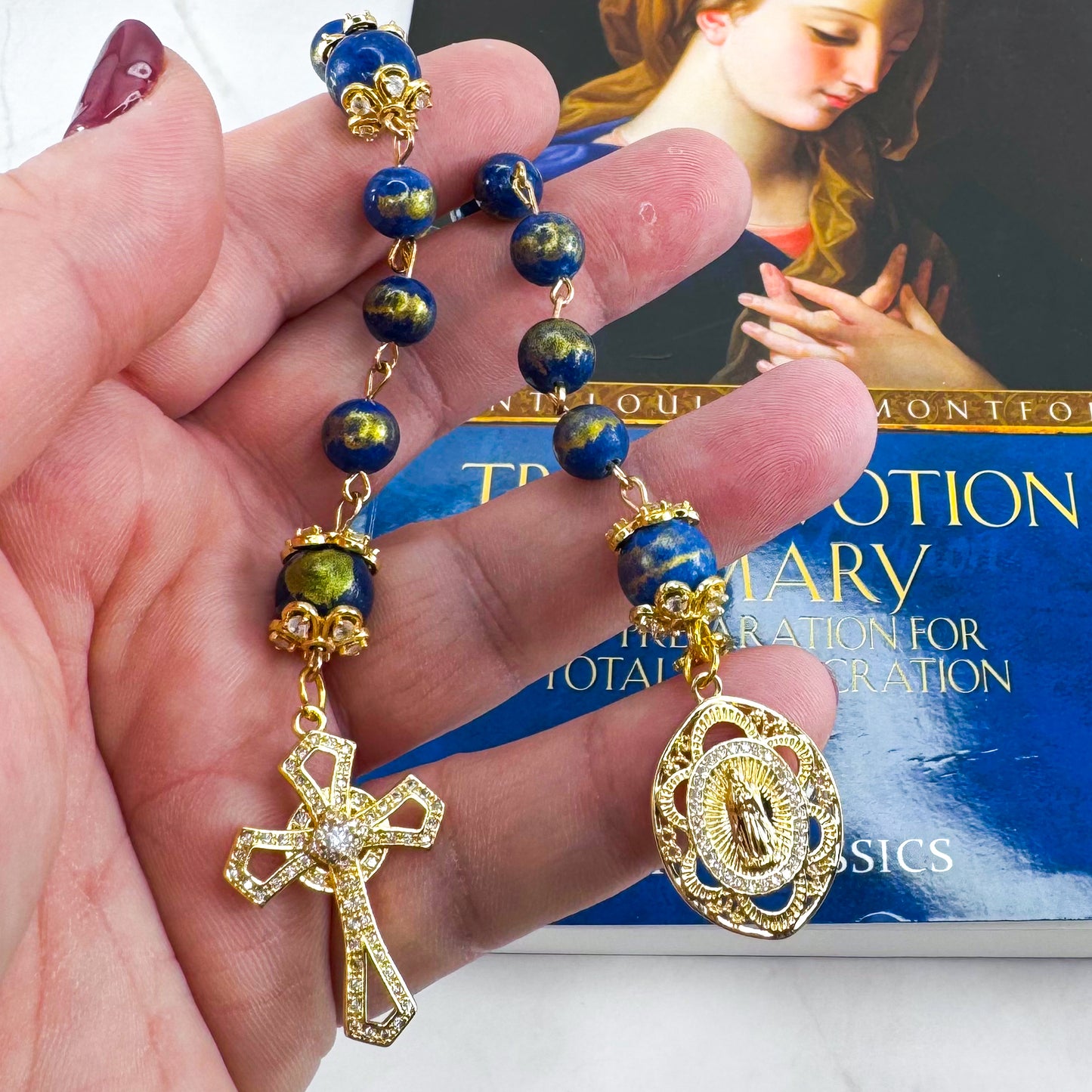 Luxury Catholic rosary bracelet handcrafted with natural Lapis Lazuli gemstone beads, a gold-tone cross with zirconia accents, and a Lady of Guadalupe medal. Adjustable beaded bracelet perfect for prayer, religious gifts, Confirmation, bridesmaid gifts, or everyday devotion. Made in Edmonton, AB, Canada.