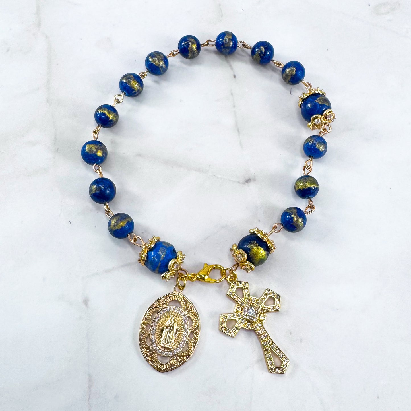 Luxury Catholic rosary bracelet handcrafted with natural Lapis Lazuli gemstone beads, a gold-tone cross with zirconia accents, and a Lady of Guadalupe medal. Adjustable beaded bracelet perfect for prayer, religious gifts, Confirmation, bridesmaid gifts, or everyday devotion. Made in Edmonton, AB, Canada.