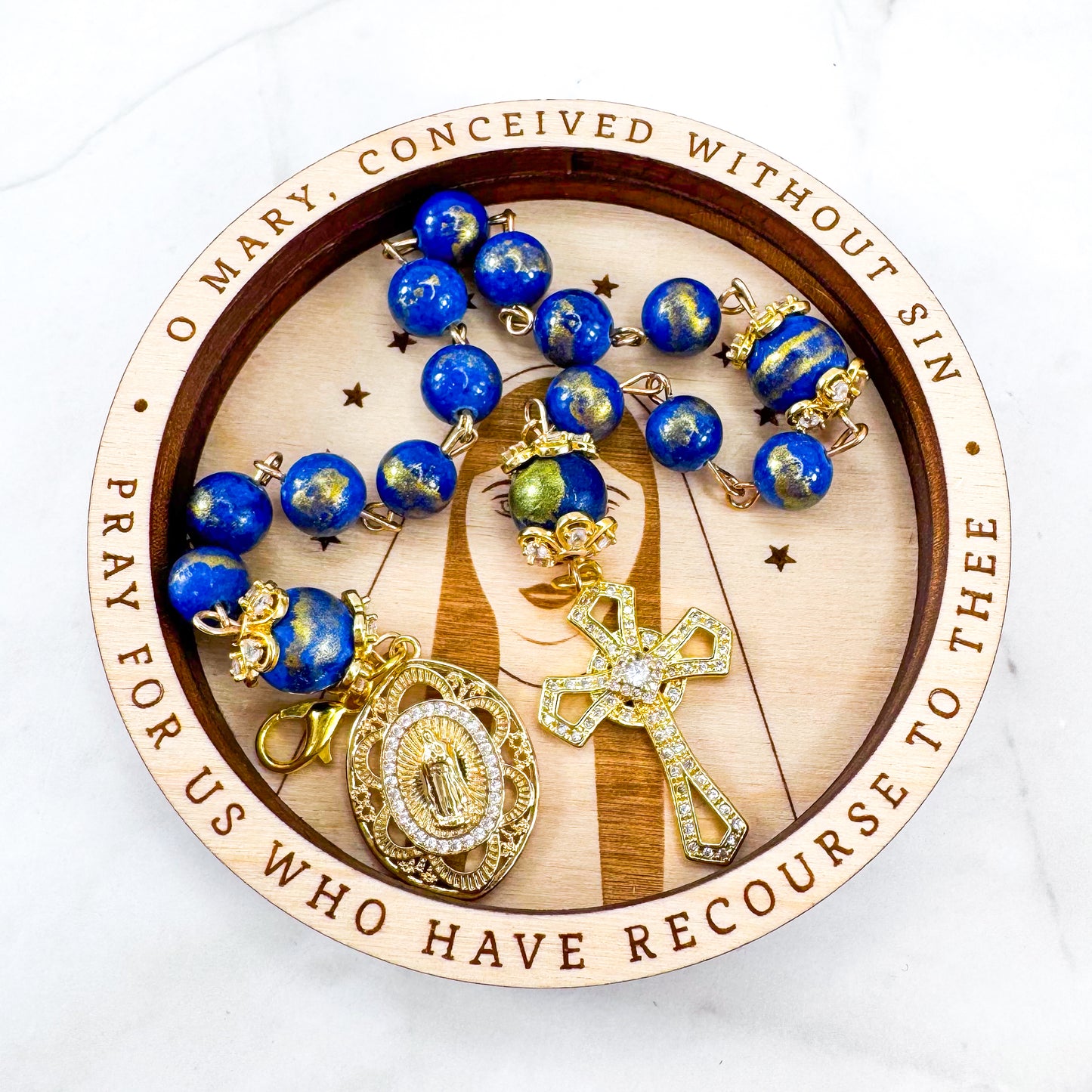 Luxury Catholic rosary bracelet handcrafted with natural Lapis Lazuli gemstone beads, a gold-tone cross with zirconia accents, and a Lady of Guadalupe medal. Adjustable beaded bracelet perfect for prayer, religious gifts, Confirmation, bridesmaid gifts, or everyday devotion. Made in Edmonton, AB, Canada.