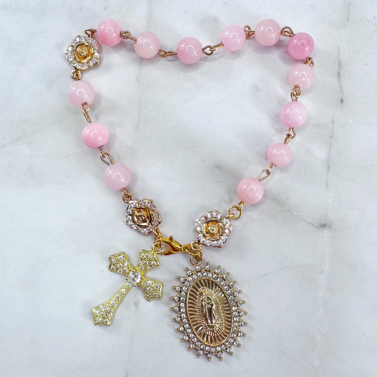 Luxury Catholic rosary bracelet handcrafted with natural rose quartz gemstone beads, a gold-tone cross with zirconia accents, and a Lady of Guadalupe medal. Adjustable beaded bracelet perfect for prayer, religious gifts, Confirmation, bridesmaid gifts, or everyday devotion. Made in Edmonton, AB, Canada.