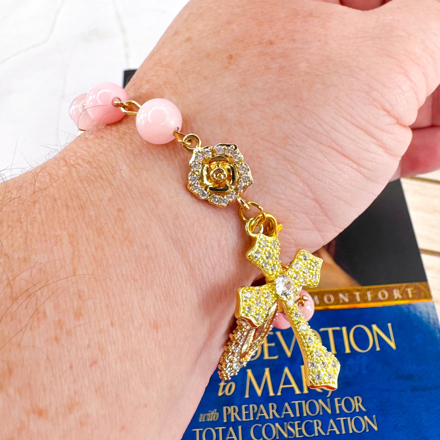 Luxury Catholic rosary bracelet handcrafted with natural rose quartz gemstone beads, a gold-tone cross with zirconia accents, and a Lady of Guadalupe medal. Adjustable beaded bracelet perfect for prayer, religious gifts, Confirmation, bridesmaid gifts, or everyday devotion. Made in Edmonton, AB, Canada.