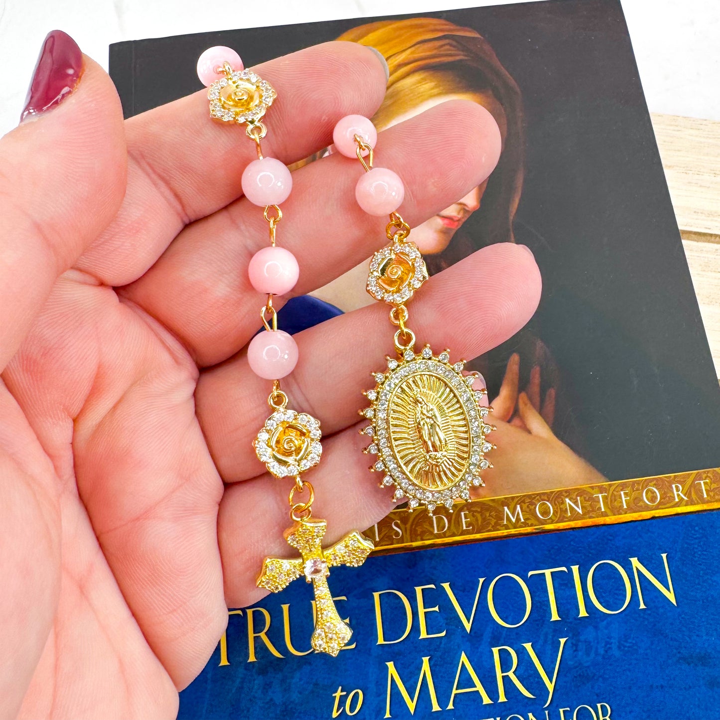 Luxury Catholic rosary bracelet handcrafted with natural rose quartz gemstone beads, a gold-tone cross with zirconia accents, and a Lady of Guadalupe medal. Adjustable beaded bracelet perfect for prayer, religious gifts, Confirmation, bridesmaid gifts, or everyday devotion. Made in Edmonton, AB, Canada.