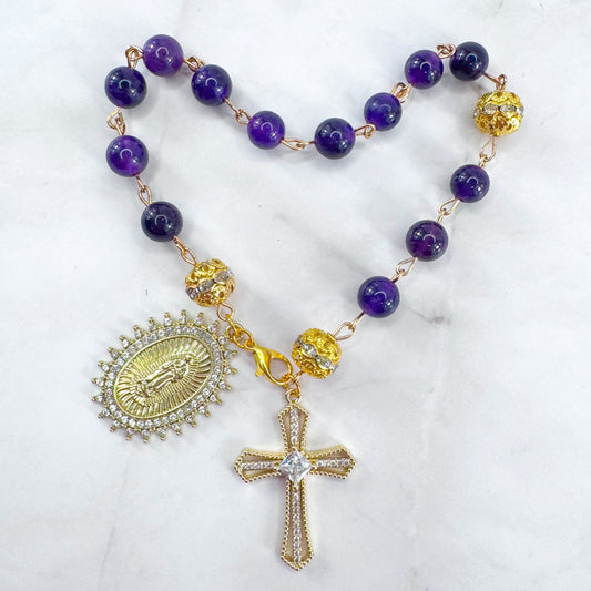Handmade Catholic rosary bracelet with amethyst beads, sparkling gold cross, and Our Lady of Guadalupe medal. Perfect for gifts or prayer. Made in Edmonton, AB, Canada.