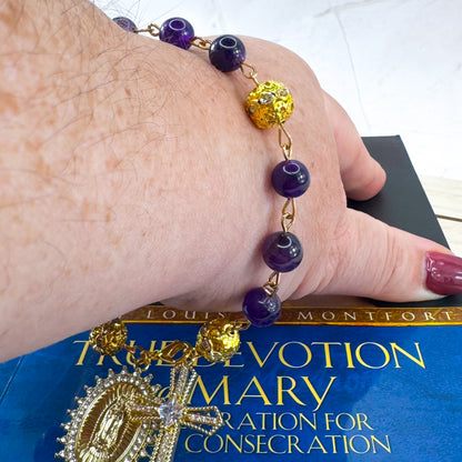 Handmade Catholic rosary bracelet with amethyst beads, sparkling gold cross, and Our Lady of Guadalupe medal. Perfect for gifts or prayer. Made in Edmonton, AB, Canada.