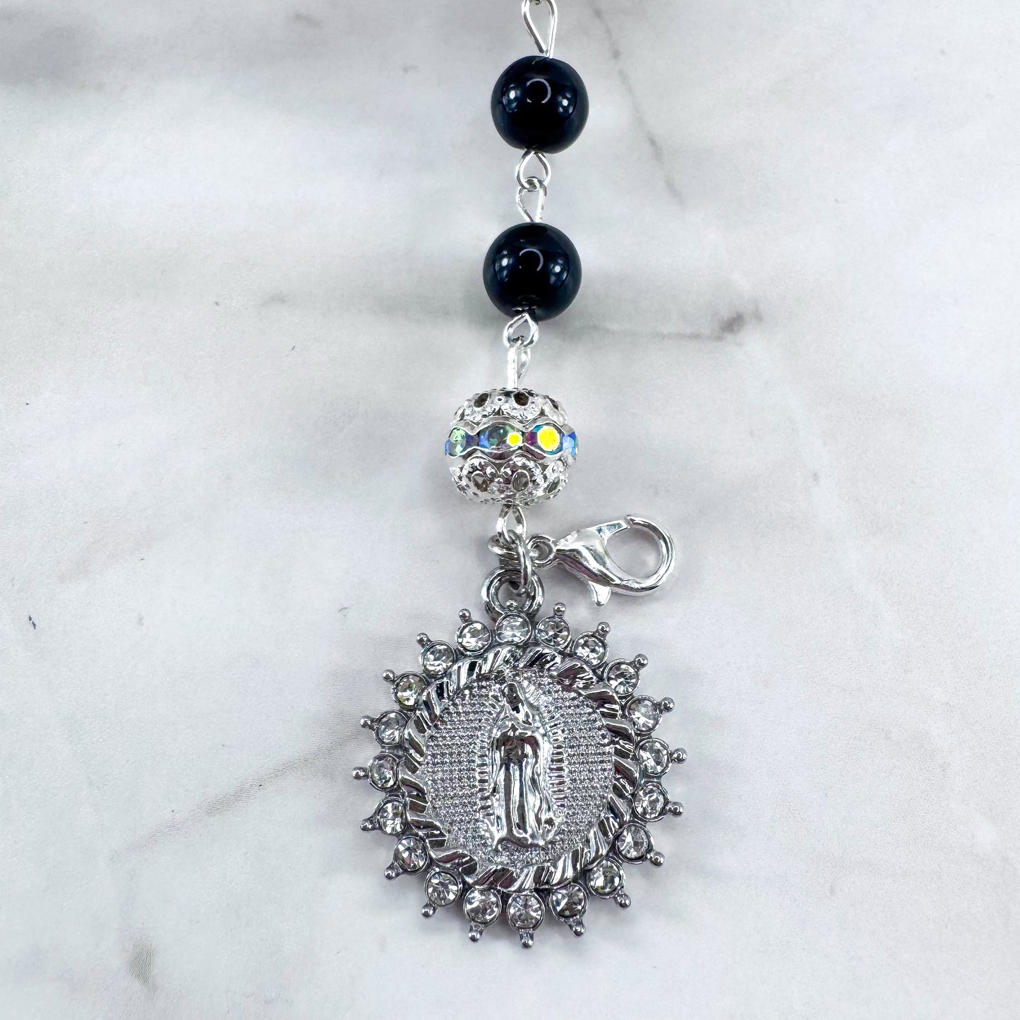 Luxury Catholic rosary bracelet handcrafted with natural black onyx gemstone beads, a silver-tone cross with zirconia accents, and a Lady of Guadalupe medal. Adjustable beaded bracelet perfect for prayer, religious gifts, Confirmation, bridesmaid gifts, or everyday devotion. Made in Edmonton, AB, Canada.