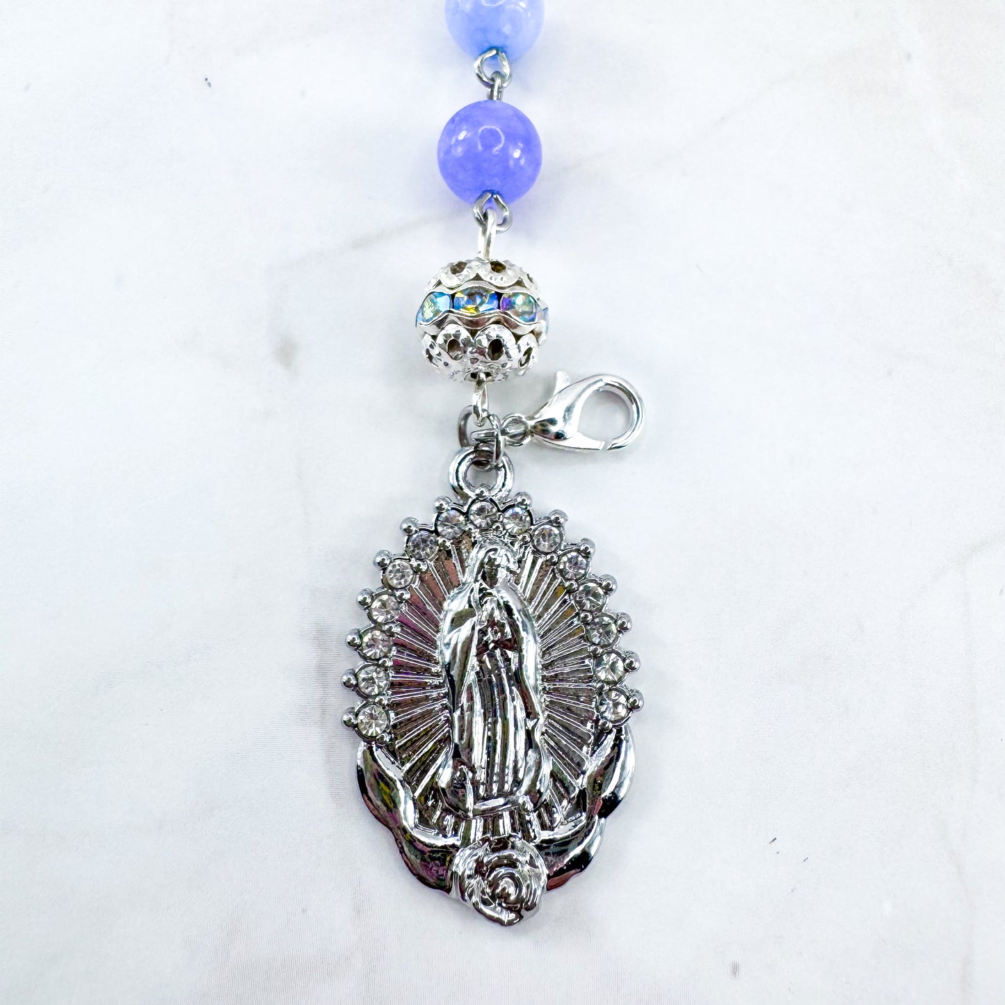 Luxury Catholic rosary bracelet handcrafted with natural Periwinkle Blue Angelite gemstone beads, a silver-tone cross with zirconia accents, and a Lady of Guadalupe medal. Adjustable beaded bracelet perfect for prayer, religious gifts, Confirmation, bridesmaid gifts, or everyday devotion. Made in Edmonton, AB, Canada.