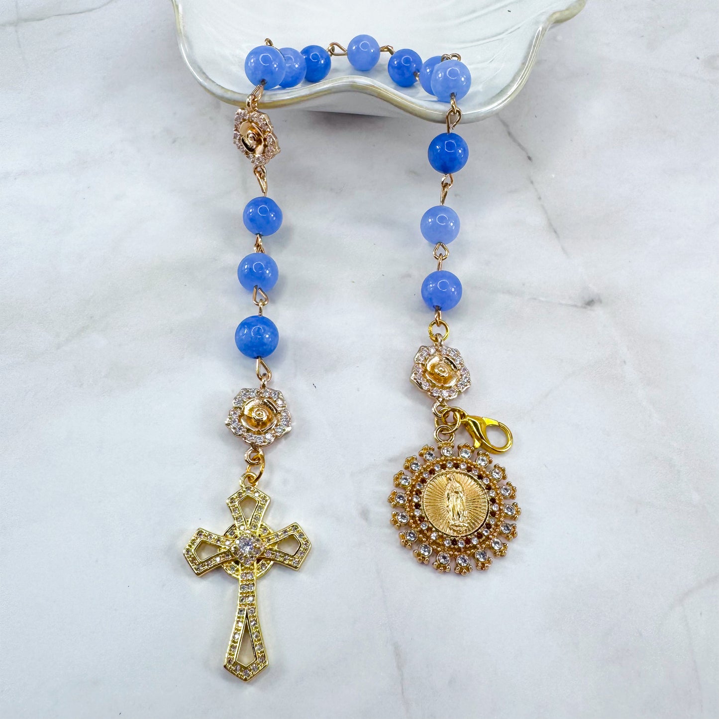 Luxury Catholic rosary bracelet handcrafted with natural blue quartz gemstone beads, a gold-tone cross with zirconia accents, and a Lady of Guadalupe medal. Adjustable beaded bracelet perfect for prayer, religious gifts, Confirmation, bridesmaid gifts, or everyday devotion. Made in Edmonton, AB, Canada
