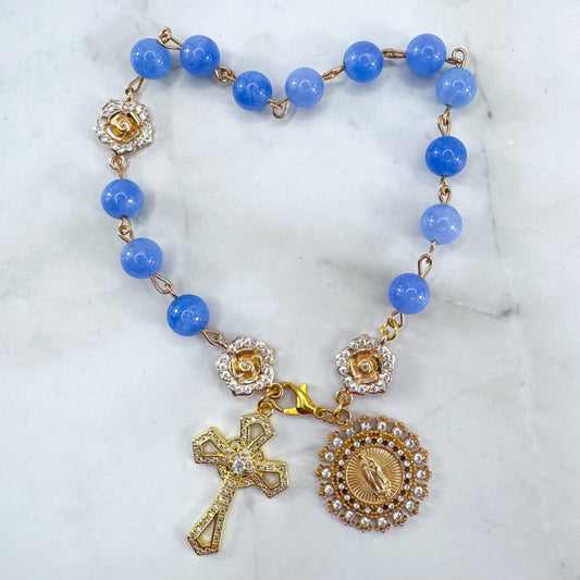 Luxury Catholic rosary bracelet handcrafted with natural blue quartz gemstone beads, a gold-tone cross with zirconia accents, and a Lady of Guadalupe medal. Adjustable beaded bracelet perfect for prayer, religious gifts, Confirmation, bridesmaid gifts, or everyday devotion. Made in Edmonton, AB, Canada.