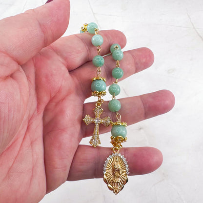 Luxury Catholic rosary bracelet handcrafted with natural Emerald Green Jade gemstone beads, a gold-tone cross with zirconia accents, and a Lady of Guadalupe medal. Adjustable beaded bracelet perfect for prayer, religious gifts, Confirmation, bridesmaid gifts, or everyday devotion. Made in Edmonton, AB, Canada.