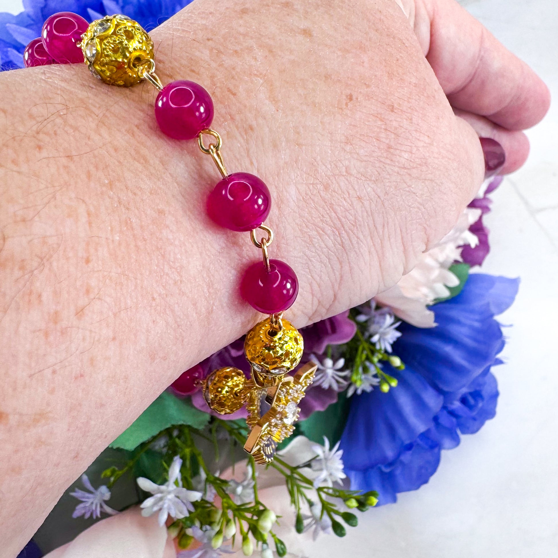 Luxury Catholic rosary bracelet handcrafted with natural Rose Red Chalcedony gemstone beads, a gold-tone cross with zirconia accents, and a Lady of Guadalupe medal. Adjustable beaded bracelet perfect for prayer, religious gifts, Confirmation, bridesmaid gifts, or everyday devotion. Made in Edmonton, AB, Canada.