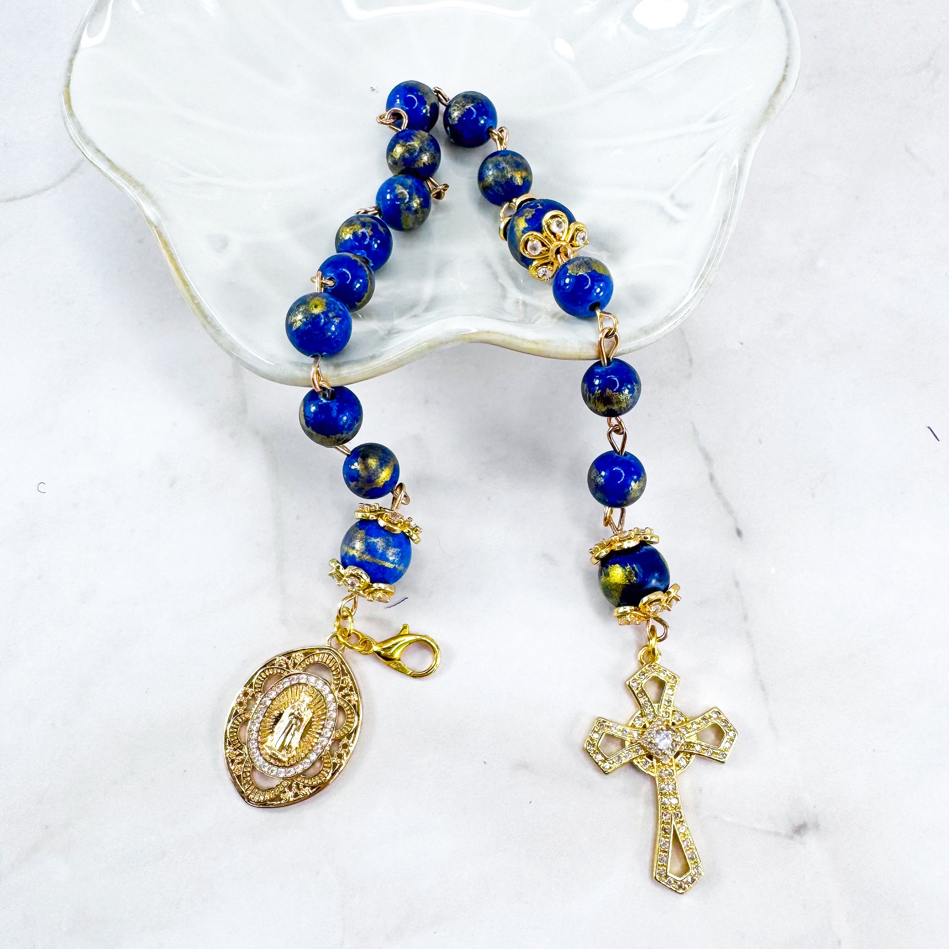 Luxury Catholic rosary bracelet handcrafted with natural Lapis Lazuli gemstone beads, a gold-tone cross with zirconia accents, and a Lady of Guadalupe medal. Adjustable beaded bracelet perfect for prayer, religious gifts, Confirmation, bridesmaid gifts, or everyday devotion. Made in Edmonton, AB, Canada.