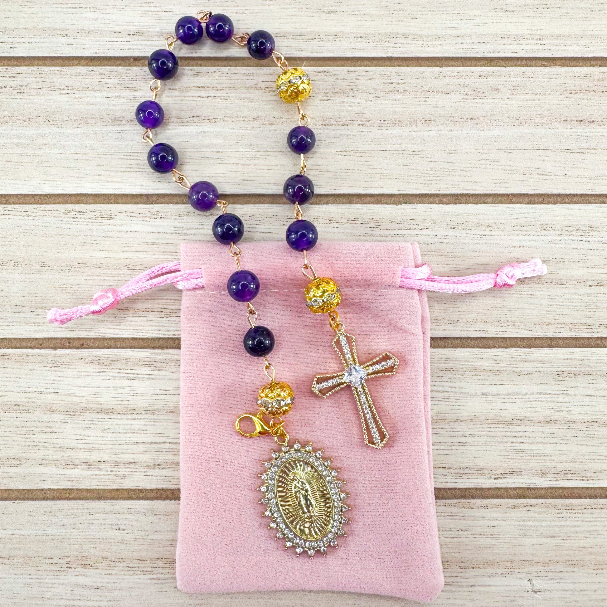 Handmade Catholic rosary bracelet with amethyst beads, sparkling gold cross, and Our Lady of Guadalupe medal. Perfect for gifts or prayer. Made in Edmonton, AB, Canada.