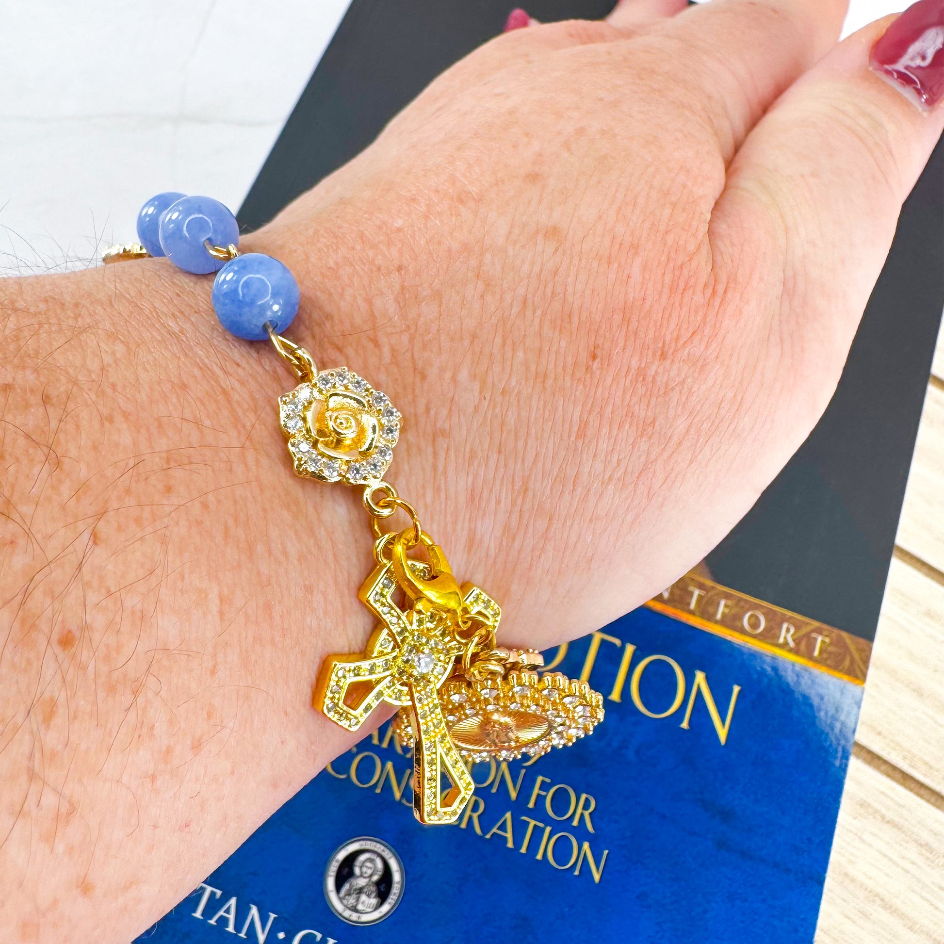 Luxury Catholic rosary bracelet handcrafted with natural blue quartz gemstone beads, a gold-tone cross with zirconia accents, and a Lady of Guadalupe medal. Adjustable beaded bracelet perfect for prayer, religious gifts, Confirmation, bridesmaid gifts, or everyday devotion. Made in Edmonton, AB, Canada.