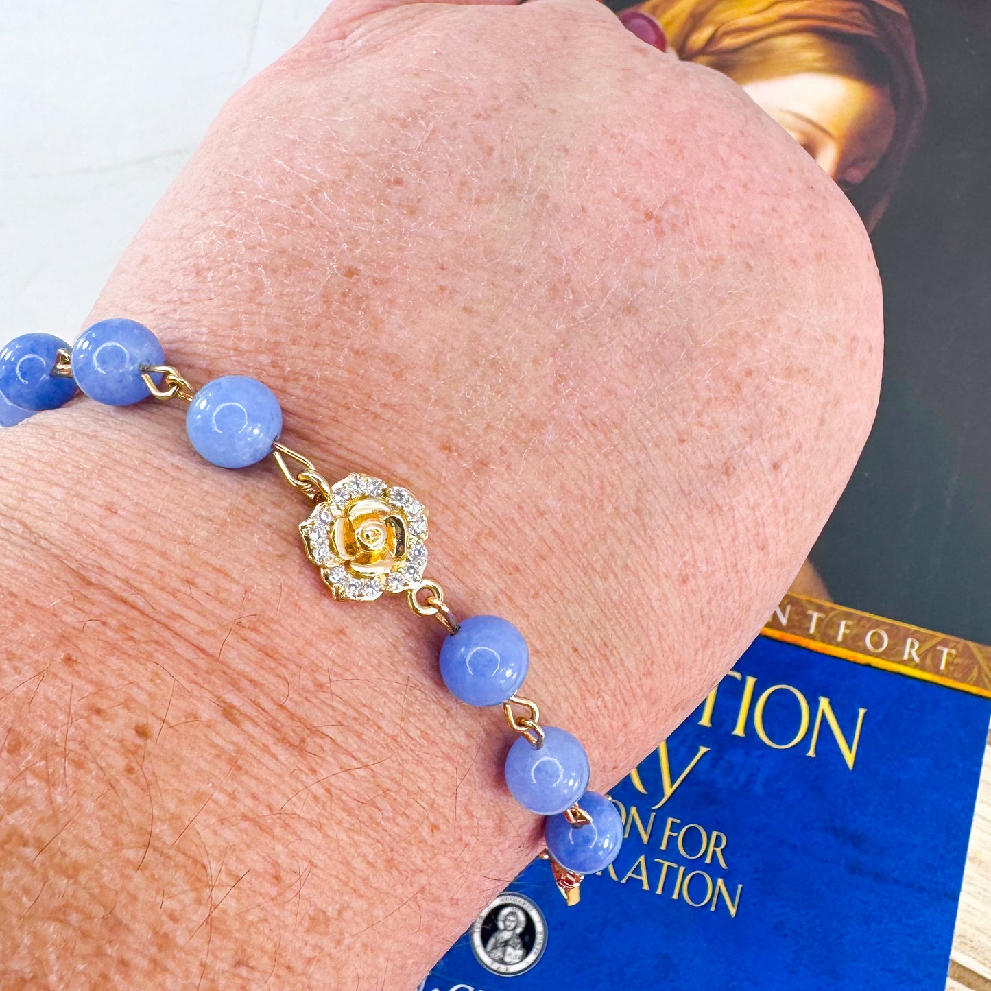Luxury Catholic rosary bracelet handcrafted with natural blue quartz gemstone beads, a gold-tone cross with zirconia accents, and a Lady of Guadalupe medal. Adjustable beaded bracelet perfect for prayer, religious gifts, Confirmation, bridesmaid gifts, or everyday devotion. Made in Edmonton, AB, Canada.