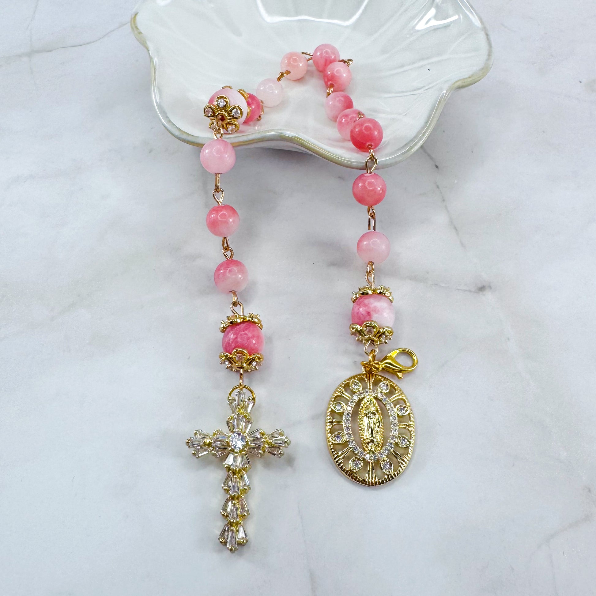 Luxury Catholic rosary bracelet handcrafted with natural pink persian jade gemstone beads, a gold-tone cross with zirconia accents, and a Lady of Guadalupe medal. Adjustable beaded bracelet perfect for prayer, religious gifts, Confirmation, bridesmaid gifts, or everyday devotion. Made in Edmonton, AB, Canada.