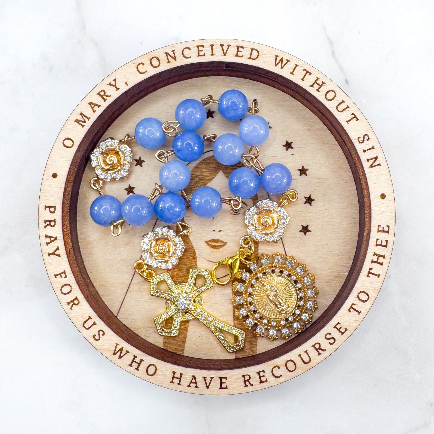 Luxury Catholic rosary bracelet handcrafted with natural blue quartz gemstone beads, a gold-tone cross with zirconia accents, and a Lady of Guadalupe medal. Adjustable beaded bracelet perfect for prayer, religious gifts, Confirmation, bridesmaid gifts, or everyday devotion. Made in Edmonton, AB, Canada.