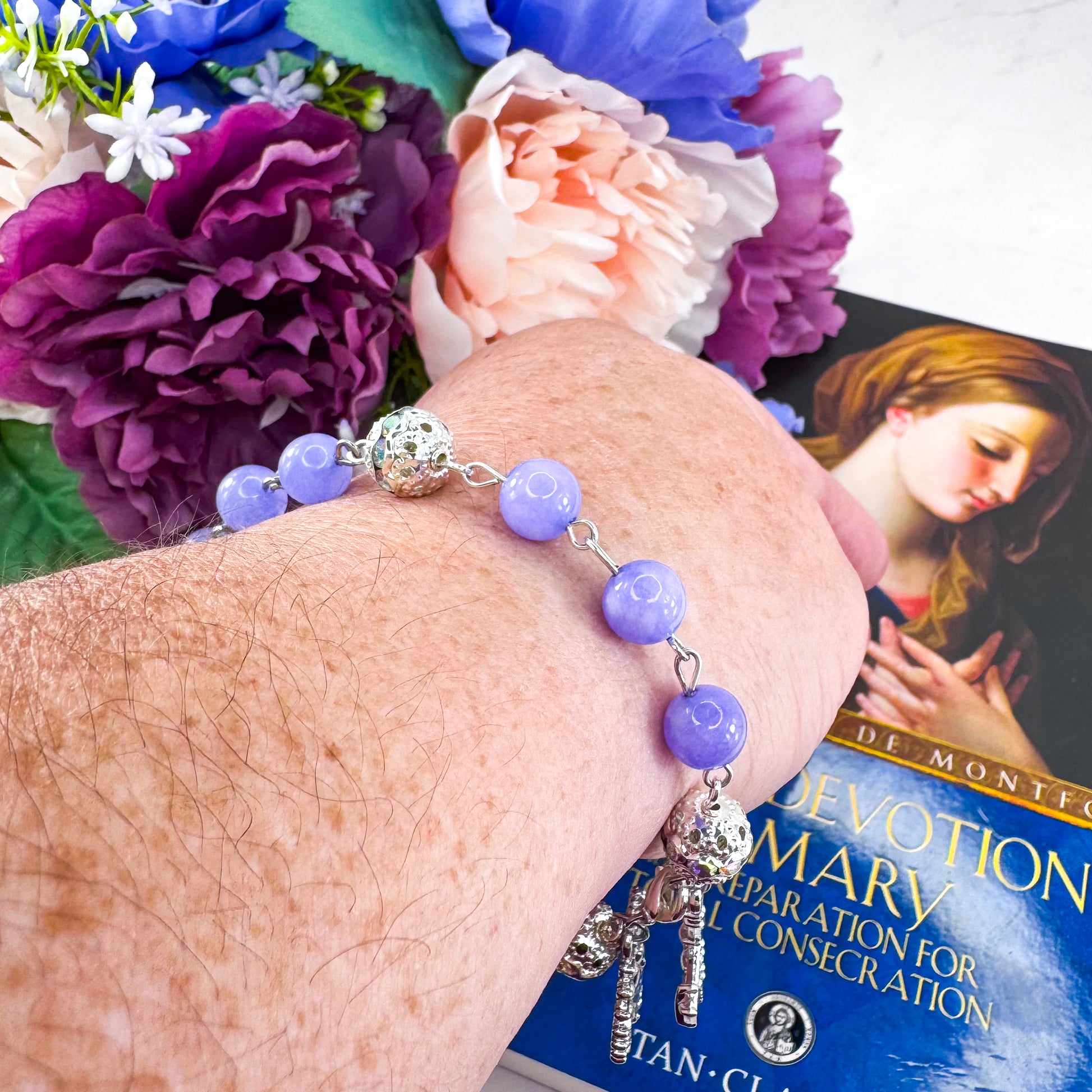 Luxury Catholic rosary bracelet handcrafted with natural Periwinkle Blue Angelite gemstone beads, a silver-tone cross with zirconia accents, and a Lady of Guadalupe medal. Adjustable beaded bracelet perfect for prayer, religious gifts, Confirmation, bridesmaid gifts, or everyday devotion. Made in Edmonton, AB, Canada.