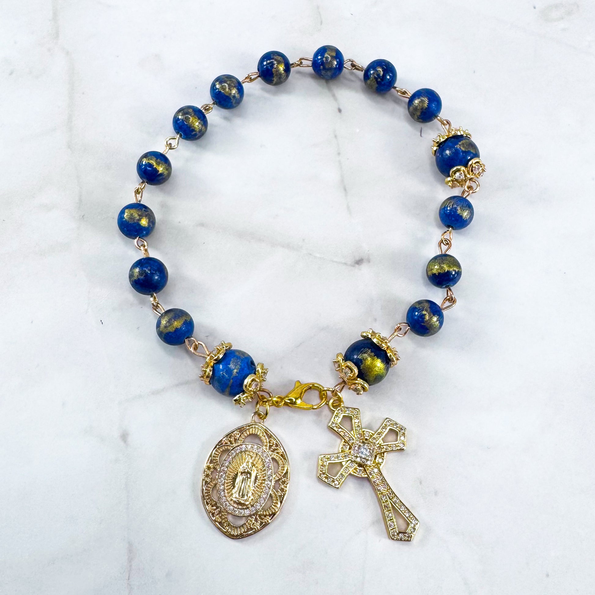 Luxury Catholic rosary bracelet handcrafted with natural Lapis Lazuli gemstone beads, a gold-tone cross with zirconia accents, and a Lady of Guadalupe medal. Adjustable beaded bracelet perfect for prayer, religious gifts, Confirmation, bridesmaid gifts, or everyday devotion. Made in Edmonton, AB, Canada.