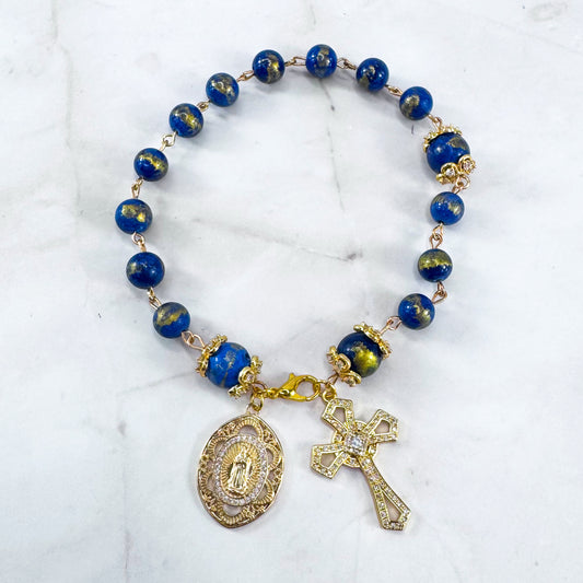 Luxury Catholic rosary bracelet handcrafted with natural Lapis Lazuli gemstone beads, a gold-tone cross with zirconia accents, and a Lady of Guadalupe medal. Adjustable beaded bracelet perfect for prayer, religious gifts, Confirmation, bridesmaid gifts, or everyday devotion. Made in Edmonton, AB, Canada.