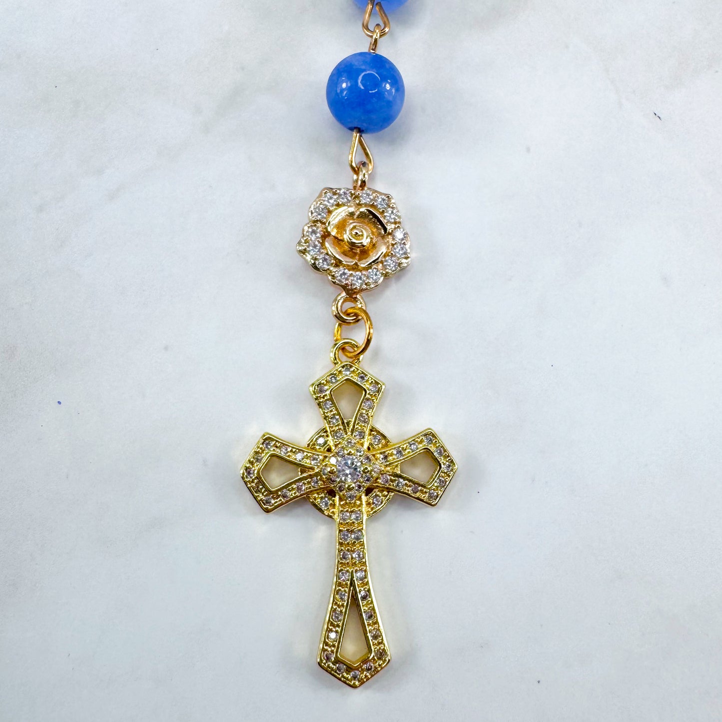 Luxury Catholic rosary bracelet handcrafted with natural blue quartz gemstone beads, a gold-tone cross with zirconia accents, and a Lady of Guadalupe medal. Adjustable beaded bracelet perfect for prayer, religious gifts, Confirmation, bridesmaid gifts, or everyday devotion. Made in Edmonton, AB, Canada.